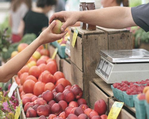 A busy traditional Colombian market with vendors selling fresh tropical fruits