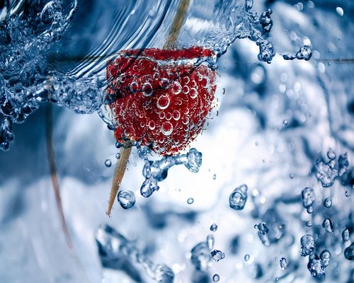 A glass of water next to fresh fruits representing daily hydration